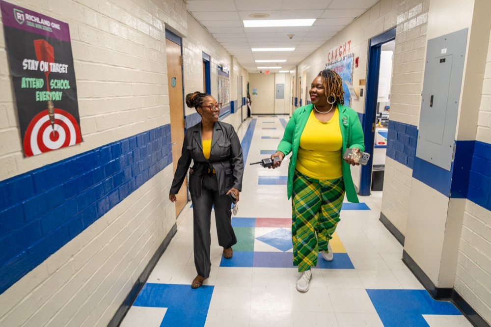 Tyra Little walking through a school with a colleague